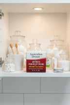 Australian Dream Arthritis Pain Relief Cream in white medicine cabinet with glass apothecary jars and wellness supplies — More4less Outlet