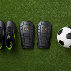 G-Form Pro-S Blade Shin Guards flat lay on soccer turf with cleats and ball