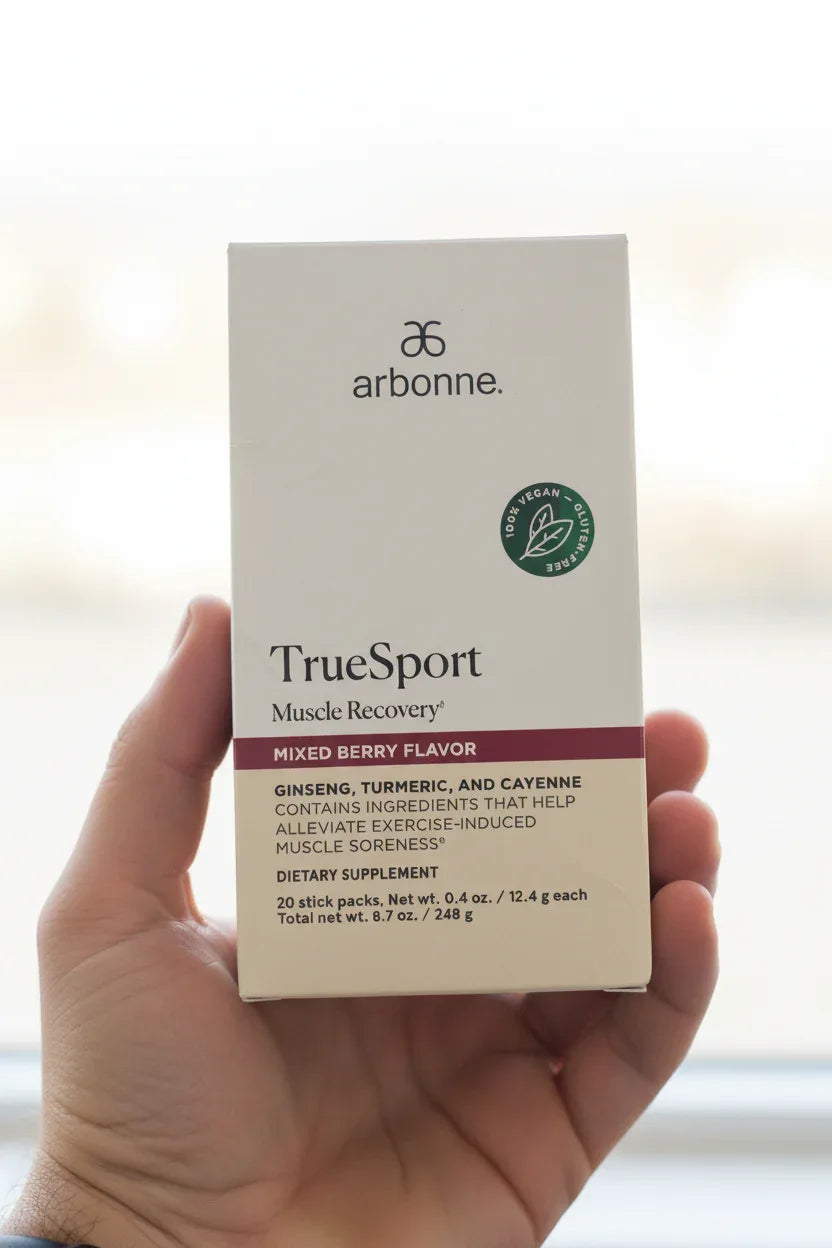 Arbonne TrueSport Muscle Recovery box in-hand close-up bright out-of-focus background