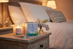 Thymes White Wisteria Candle burning with soft flame on bedroom nightstand cozy atmosphere - More4less Outlet
