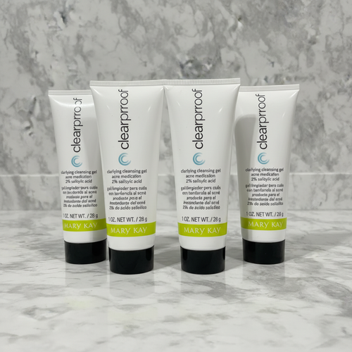 Four Mary Kay Clear Proof Clarifying Cleansing Gel tubes standing upright on grey marble - studio shot