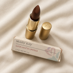 Mary Kay Bistro Bronze 4199 lipstick, gold cap and retail box on cream fabric