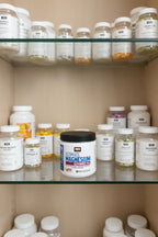 Force Factor Magnesium powder jar on wellness pantry cabinet glass shelves with vitamins