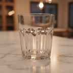Close-up of clear German crystal glass with subtle optical texture reflecting warm ambient lighting on a marble countertop