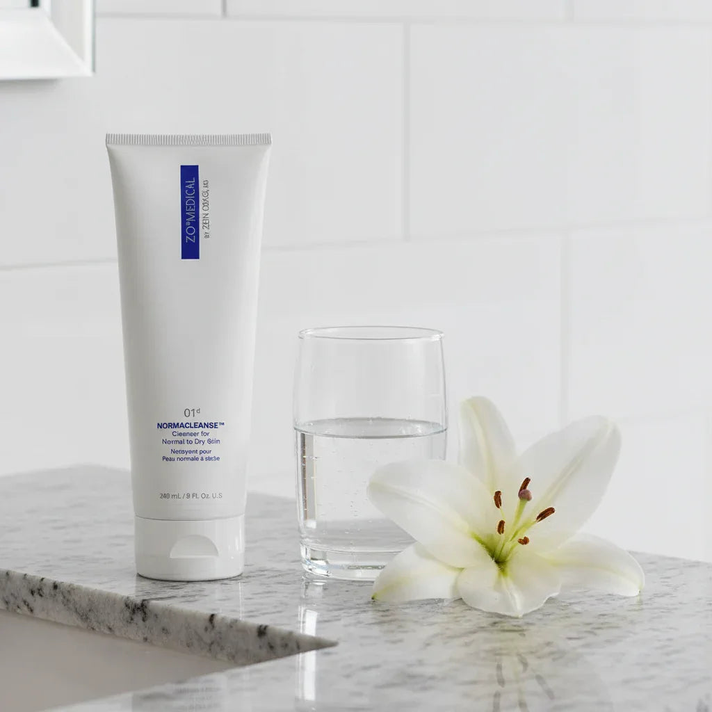 Premium ZO Skin Health Normacleanse facial wash on granite vanity with water glass and white lily purity hydration