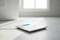 Taylor Digital Bath Scale on white marble bathroom floor with blue backlit display showing weight