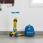 Yellow and blue kids folding scooter leaning against garage wall showing compact fold storage — Mongoose Force 1.0 — More4less Outlet
