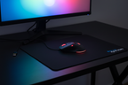 Corsair Raptor M3 black gaming mouse with red LED scroll wheel on ROCCAT Kanga black cloth mousepad on dark gaming desk with RGB monitor