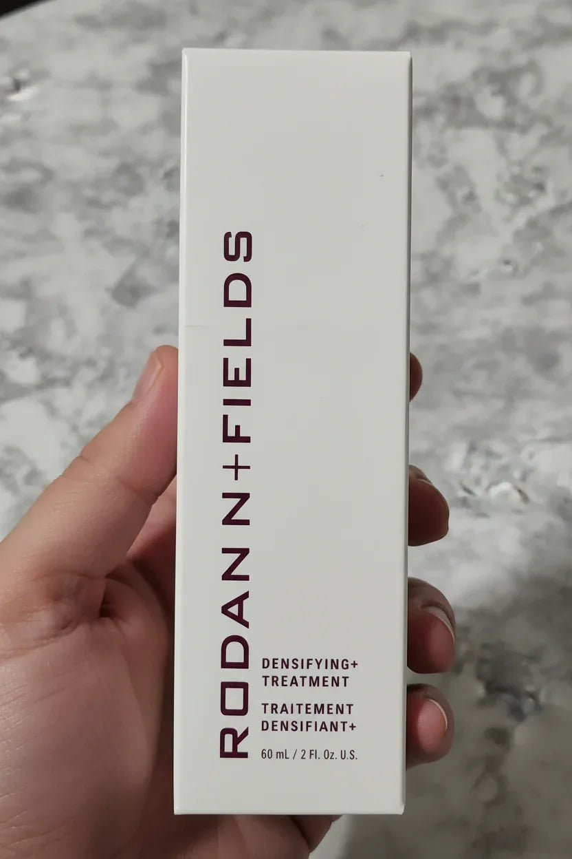 In-hand macro focus on Rodan + Fields Densifying+ Treatment box showing R+F branding and treatment name