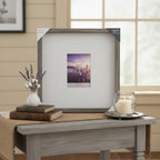 Rustic farmhouse tabletop decor featuring a large square matted picture frame on a side table