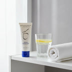ZO Skin Health cleanser on organized white bathroom shelf with lemon water and spa towel