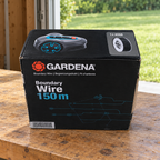 GARDENA Boundary Wire 150 m box on a garage workbench near a lawn