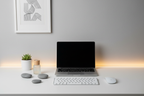 Professional minimalist desk setup with zen wellness items including small essential oil bottle and smooth stone fidget tools