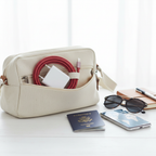 Travel bag with compact white USB-C wall charger and cranberry braided Lightning cable beside passport and phone — More4less Outlet