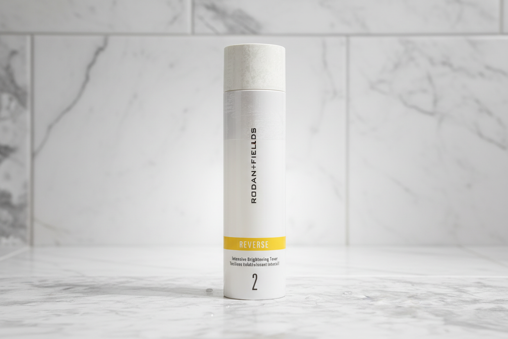 Rodan + Fields REVERSE Intensive Brightening Toner bottle on high-end white bathroom tile with radiant soft light