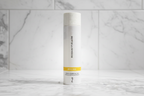 Rodan + Fields REVERSE Intensive Brightening Toner bottle on high-end white bathroom tile with radiant soft light