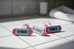 Smooth women's razor cartridges on clean white bathroom tile in soft natural lighting