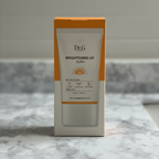 AI-generated lifestyle image of Dr.G Brightening Up Sun+ SPF50+ PA+++ 50 mL retail box on a pale stone bathroom counter