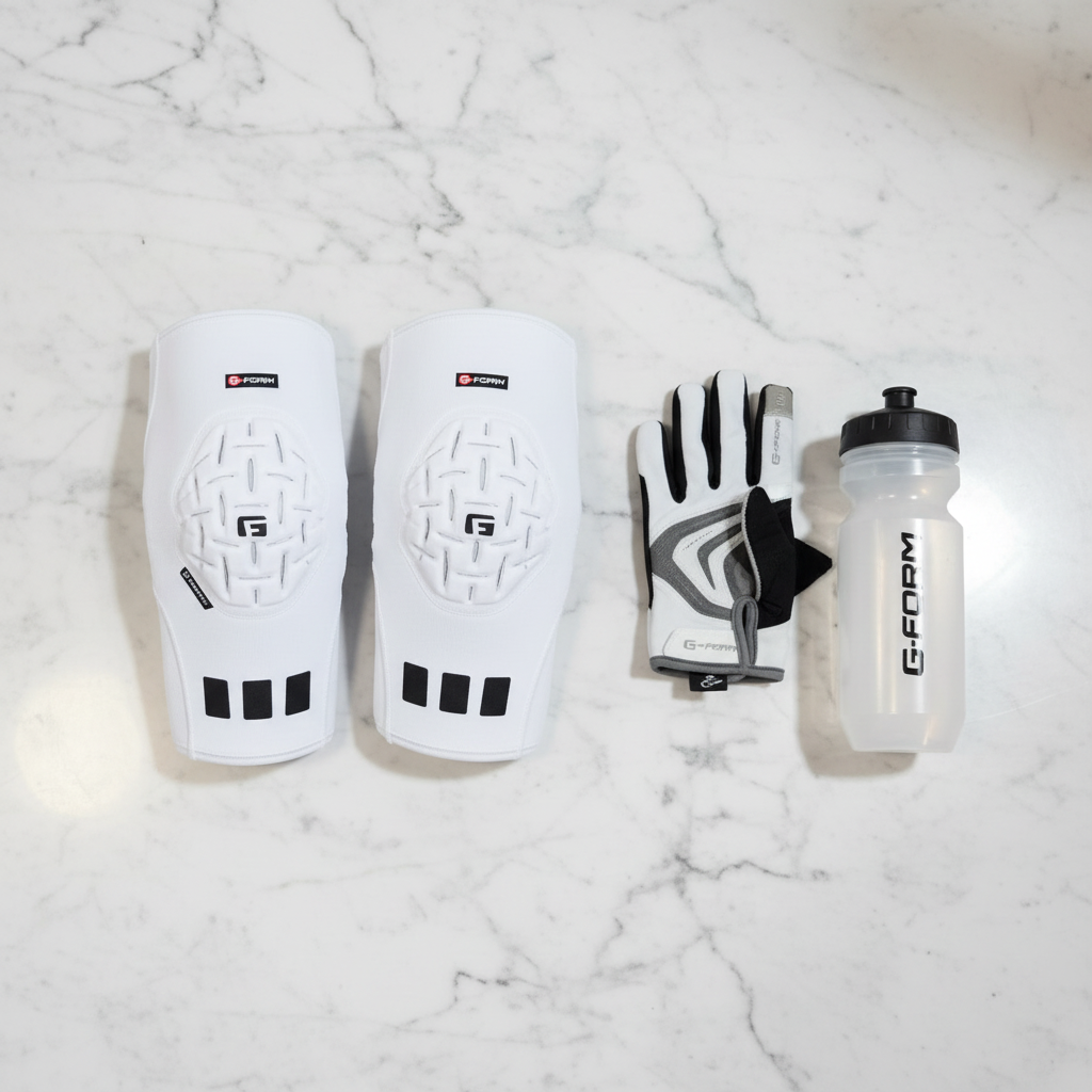 G-Form Pro Knee Sleeves flat lay on marble surface with cycling gloves and water bottle