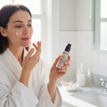 Woman applying Mary Kay TimeWise Daytime Defender SPF 30 in bright sunlit bathroom morning skincare routine