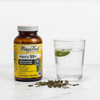 Men's advanced multivitamin amber glass bottle beside water glass and green tea leaves on white marble countertop – More4less Outlet