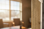 Close-up macro of weathered wood grain finish and protective display glass in sun-lit home