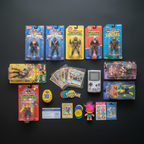 Flat lay of 90s retro toys and collectibles in packaging on dark matte surface — More4less Outlet