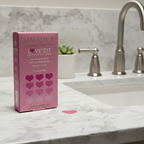Pink heart-shaped hydrocolloid acne patches box in soft natural window light on white quartz bathroom countertop – More4less Outlet