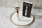 Organized skincare display on a white ceramic tray with gold accents featuring the Galahome Sonic Face Massager