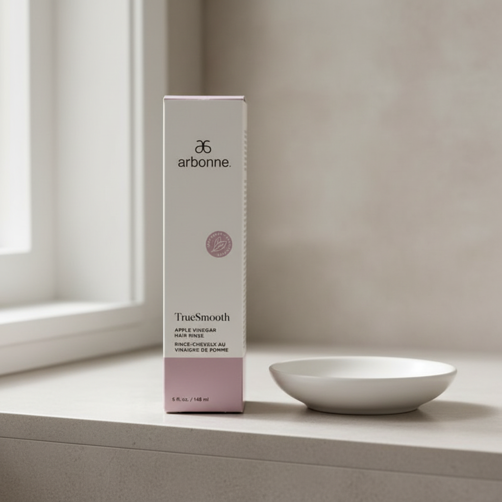 Arbonne TrueSmooth Apple Vinegar Hair Rinse 5 fl oz package on a neutral shelf beside a folded towel