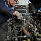 Mechanic reaching into tight engine bay with compact stubby black and grey air impact wrench