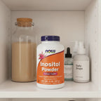 NOW Foods Inositol Powder 8oz bottle on minimalist health cabinet shelf with premium apothecary containers and soft interior cabinet lighting