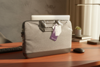 Targus Strata grey heather laptop sleeve resting on mahogany desk in warm sunlight, professional workspace
