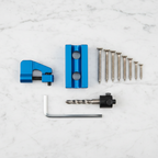 Lifestyle — blue pocket-hole jig kit laid out on white marble beside wood screws, hex wrench, drill bit, and stop collar — tool flatlay editorial for visual context only