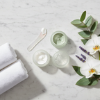 Elegant flat lay of premium face mask products and botanicals on marble