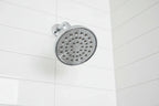 Professional interior photo showcasing polished chrome showerhead aesthetic bathroom hardware on white tile