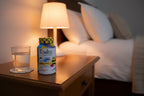 Zarbee's Children's Calm gummies bottle on evening bedside table with glass of water warm light