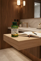 Nature's Bounty Ashwagandha KSM-66 90 Tablets on wood vanity shelf with health journal in dark-oak bathroom setting — More4less Outlet.