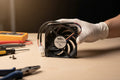 Hand holding a precision appliance condenser fan motor next to repair tools