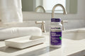 Natrol Biotin bottle on bathroom vanity countertop morning sunlight ceramic tray wellness lifestyle