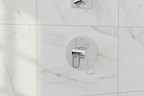 Grohe BauLoop polished chrome shower valve trim on white marble tile in minimalist contemporary bathroom with morning light