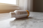 Rodan + Fields REVERSE Intensive Brightening Toner reflecting soft natural window light on white marble
