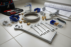 Professional plumbing tools laid out neatly on tile floor for bathroom fixture installation project