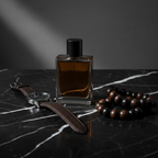 Lifestyle image - dark amber cologne bottle on black marble with leather watch and wooden beads, moody editorial men's grooming flatlay for visual context only