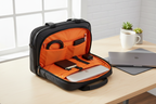 Solo New York Ace Slim Brief open on desk showing bright orange interior lining with laptop — More4less Outlet