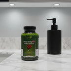 Irwin Naturals Prosta-Strong RED bottle on marble bathroom vanity with matte black soap dispenser