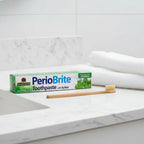 Nature's Answer PerioBrite Coolmint Toothpaste 3-Pack on upscale quartz bathroom vanity with bamboo toothbrush and white hand towel
