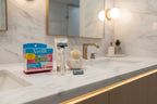 Clean modern bathroom vanity featuring premium women's shaving supplies and soft lighting on white marble