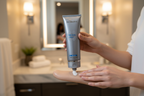 SkinMedica TNS Body Lotion being applied to woman forearm during luxury skincare routine