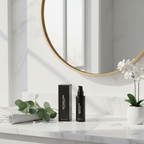 Revision Skincare Vitamin K Serum black box and pump bottle on elegant vanity with eucalyptus and white orchid in morning light